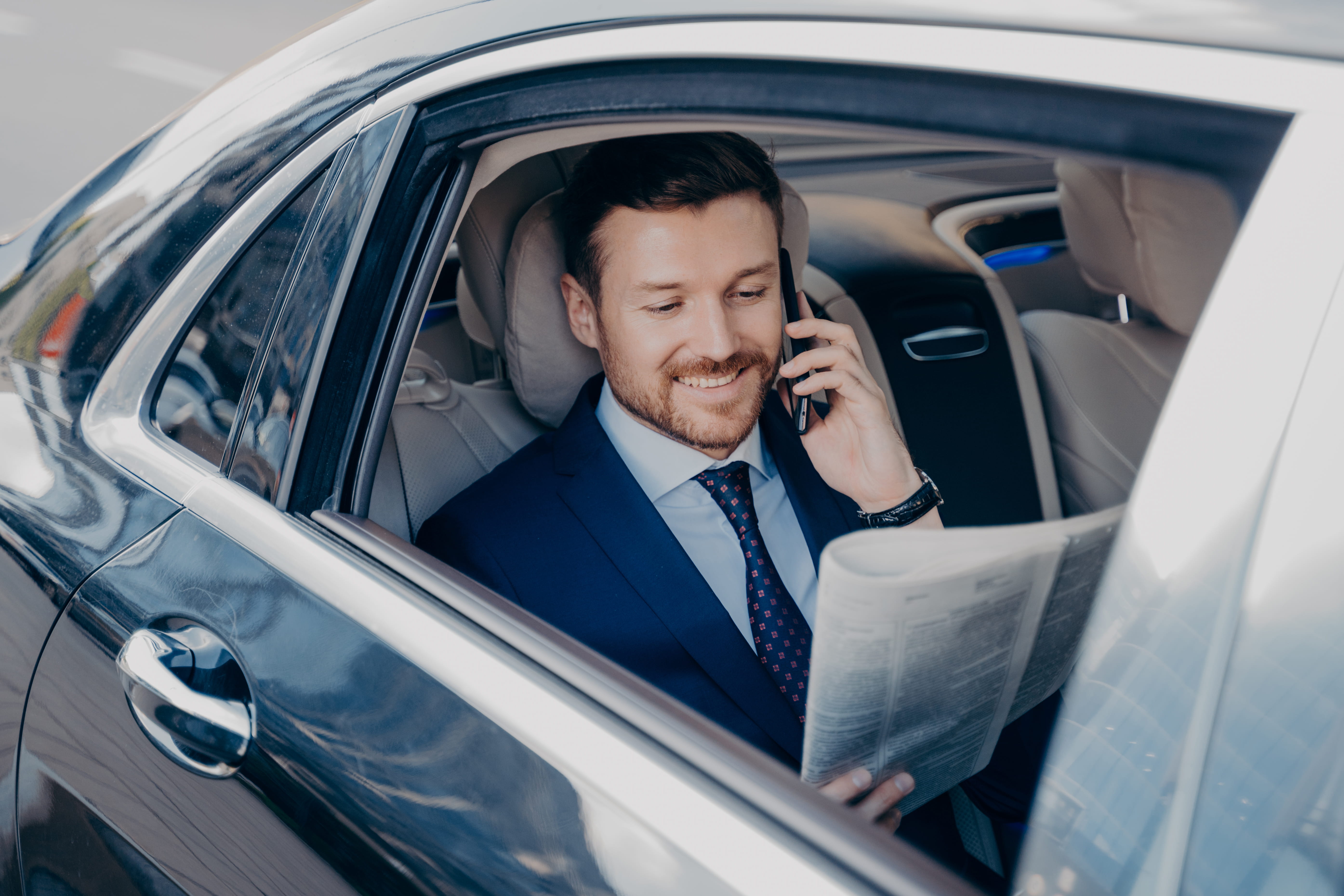 Business traveller in a luxury car during an airport transfer